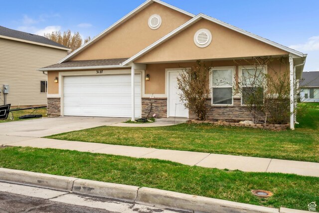 3127 W 525 N, West Point, UT 84015 - view of front facade featuring driveway, a front yard, stone siding, stucco siding, and a garage