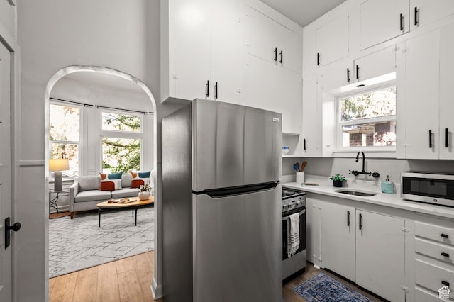 655 S 800 E, Salt Lake City, UT 84102 - kitchen with light countertops, light wood-type flooring, stainless steel appliances, a sink, and white cabinets