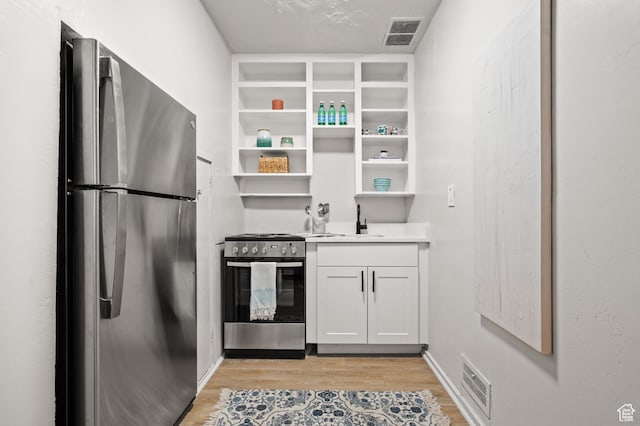 655 S 800 E, Salt Lake City, UT 84102 - kitchen featuring open shelves, stainless steel appliances, a sink, light wood finished floors, and visible vents