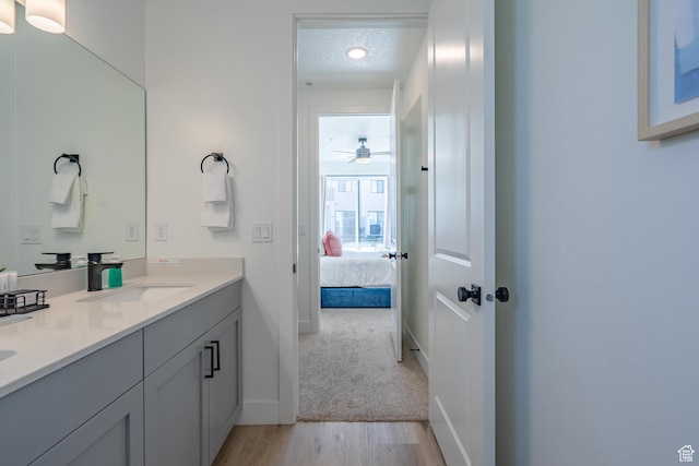 5399 S Cerulean Ln Unit 95, St George, UT 84790 - ensuite bathroom featuring vanity, a textured ceiling, connected bathroom, a ceiling fan, and wood finished floors