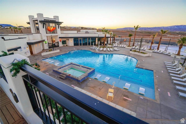 5399 S Cerulean Ln Unit 95, St George, UT 84790 - pool at dusk with a community pool, a patio area, a mountain view, and a hot tub