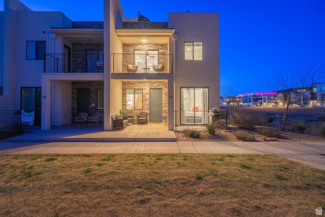 5399 S Cerulean Ln Unit 95, St George, UT 84790 - view of front of house featuring a balcony, stone siding, stucco siding, and a patio area
