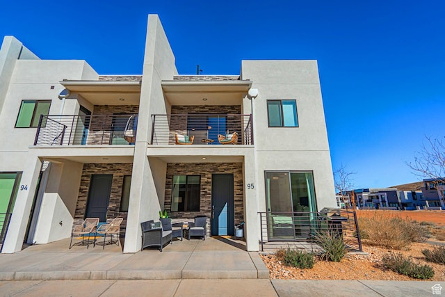 5399 S Cerulean Ln Unit 95, St George, UT 84790 - back of property with a balcony, an outdoor hangout area, stucco siding, and a patio area