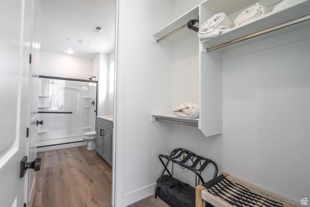 5399 S Cerulean Ln Unit 95, St George, UT 84790 - full bathroom with visible vents, toilet, wood finished floors, vanity, and a stall shower