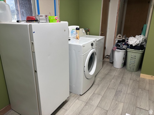 clothes washing area with wood tiled floor, washer and clothes dryer, and laundry area