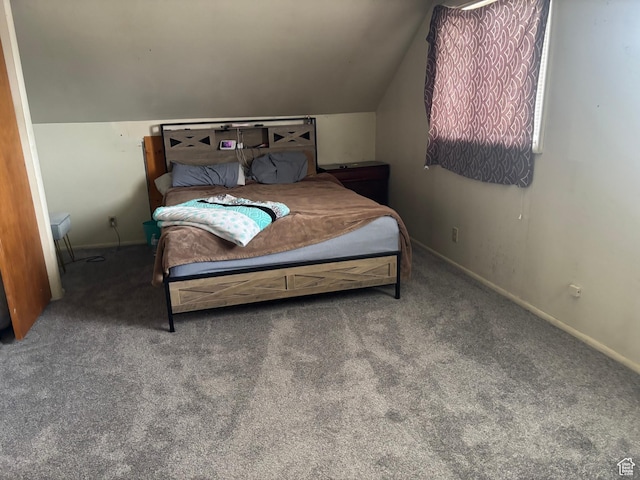 bedroom featuring baseboards, lofted ceiling, and carpet