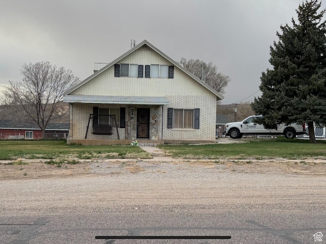 bungalow featuring covered porch and brick siding