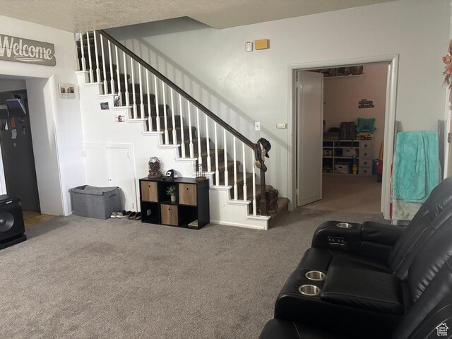 living room featuring carpet and stairs