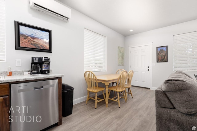 dining area featuring a wall mounted AC, baseboards, and light wood finished floors