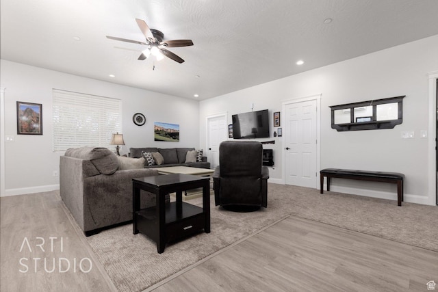 living area featuring baseboards, ceiling fan, light wood-style flooring, and recessed lighting
