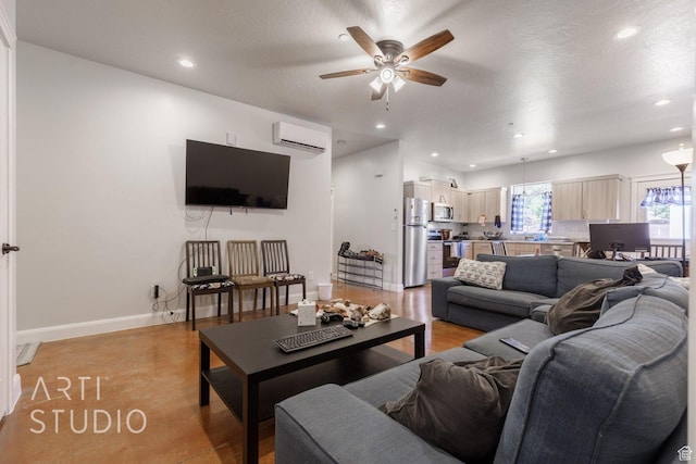 living room featuring a ceiling fan, a wall unit AC, a textured ceiling, baseboards, and recessed lighting