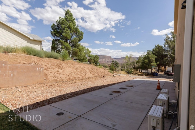view of patio / terrace featuring fence and a mountain view