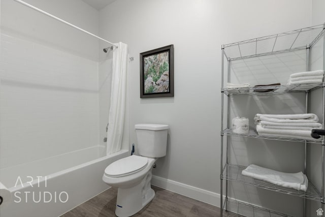 bathroom featuring toilet, shower / bath combo, baseboards, and wood finished floors