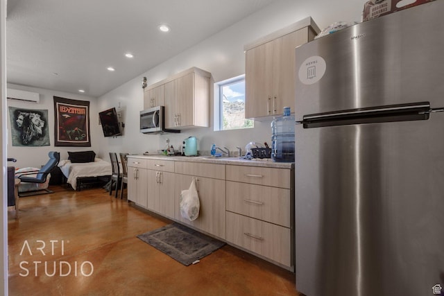 kitchen with light brown cabinets, concrete floors, light countertops, and stainless steel appliances