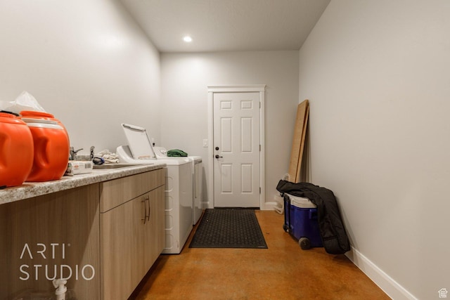 laundry room with baseboards, washer and dryer, recessed lighting, and a sink