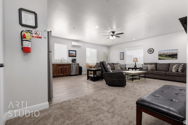 living area featuring a wall mounted AC, recessed lighting, baseboards, a ceiling fan, and light carpet