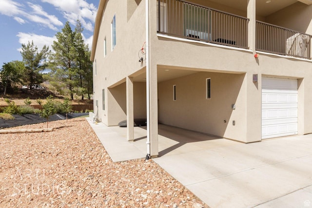 view of property exterior with stucco siding and concrete driveway