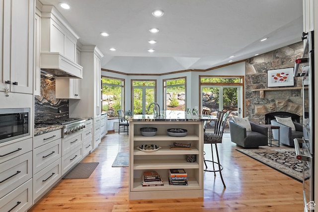 5888 E Pioneer Fork Rd N, Salt Lake City, UT 84108 - kitchen with light wood-style flooring, stainless steel gas cooktop, a fireplace, open shelves, and built in microwave