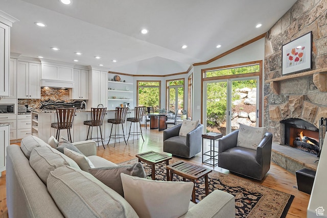 5888 E Pioneer Fork Rd N, Salt Lake City, UT 84108 - living room with a healthy amount of sunlight, a stone fireplace, lofted ceiling, and light wood-type flooring