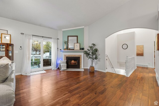 13968 S Hawberry Rd E, Draper, UT 84020 - unfurnished living room featuring a fireplace with flush hearth, lofted ceiling, wood finished floors, and arched walkways