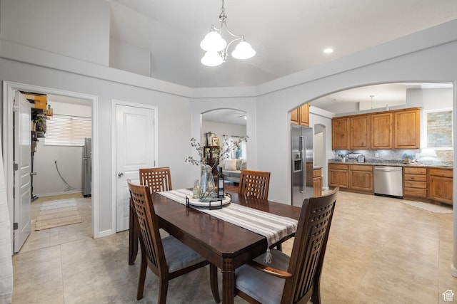 13968 S Hawberry Rd E, Draper, UT 84020 - dining space with light tile patterned floors, arched walkways, a healthy amount of sunlight, and a chandelier