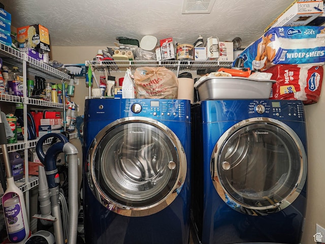 laundry room with washing machine and clothes dryer, laundry area, and a textured ceiling