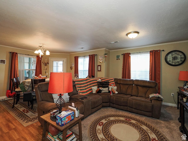 living room with ornamental molding, baseboards, a chandelier, and wood finished floors