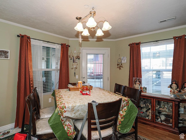dining space with a healthy amount of sunlight, light wood-style flooring, visible vents, and an inviting chandelier