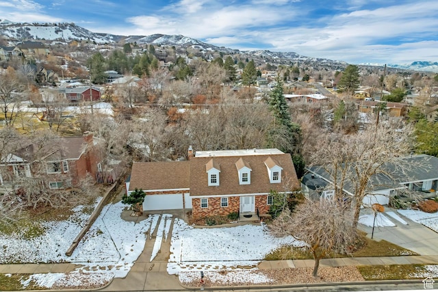 snowy aerial view with a residential view and a mountain view