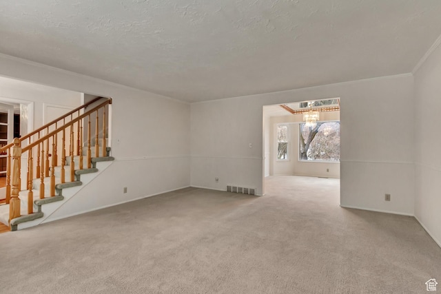 unfurnished living room featuring stairway, a textured ceiling, visible vents, carpet, and an inviting chandelier
