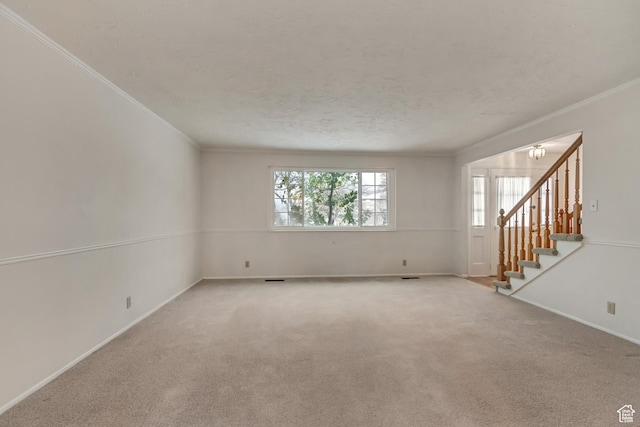 spare room featuring stairs, ornamental molding, a chandelier, and light colored carpet