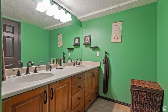3125 E Kennedy Dr S Unit 605, Salt Lake City, UT 84108 - bathroom featuring double vanity, a textured ceiling, a sink, and tile patterned flooring