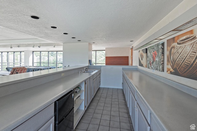 3125 E Kennedy Dr S Unit 605, Salt Lake City, UT 84108 - kitchen featuring light tile patterned flooring, open floor plan, light countertops, and a textured ceiling