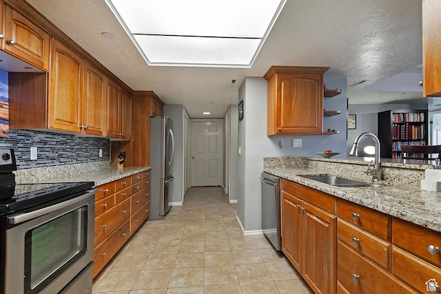 3125 E Kennedy Dr S Unit 605, Salt Lake City, UT 84108 - kitchen with a sink, light tile patterned flooring, light stone counters, appliances with stainless steel finishes, and brown cabinetry