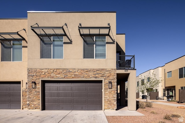 view of front of property with stucco siding, stone siding, and a garage
