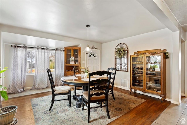 dining space featuring wood finished floors, baseboards, and visible vents