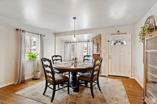 dining space with baseboards and wood finished floors