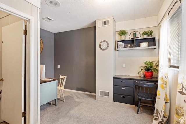 carpeted office space featuring baseboards and visible vents