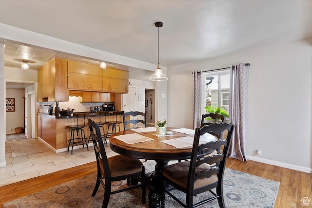 dining room featuring baseboards and light wood finished floors