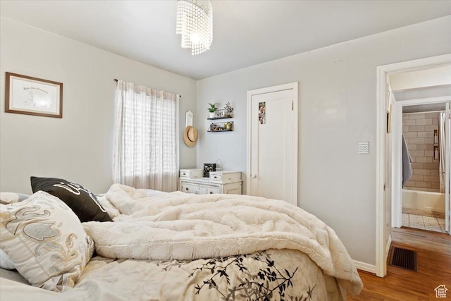 bedroom featuring visible vents, baseboards, and wood finished floors