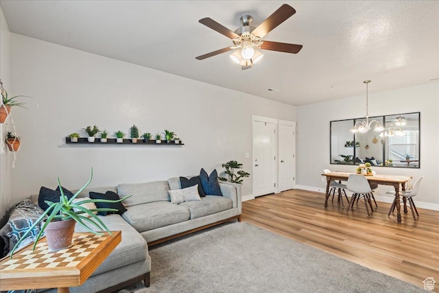 14506 S Ronan Ln Unit 203, Herriman, UT 84096 - living room with ceiling fan with notable chandelier, wood finished floors, and baseboards