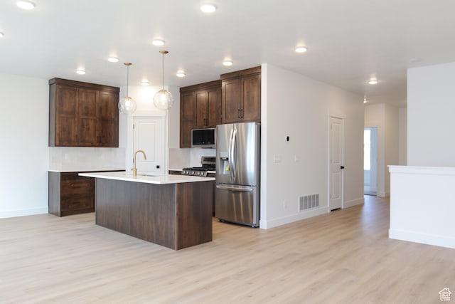 kitchen with dark brown cabinets, baseboards, light wood finished floors, visible vents, and stainless steel appliances