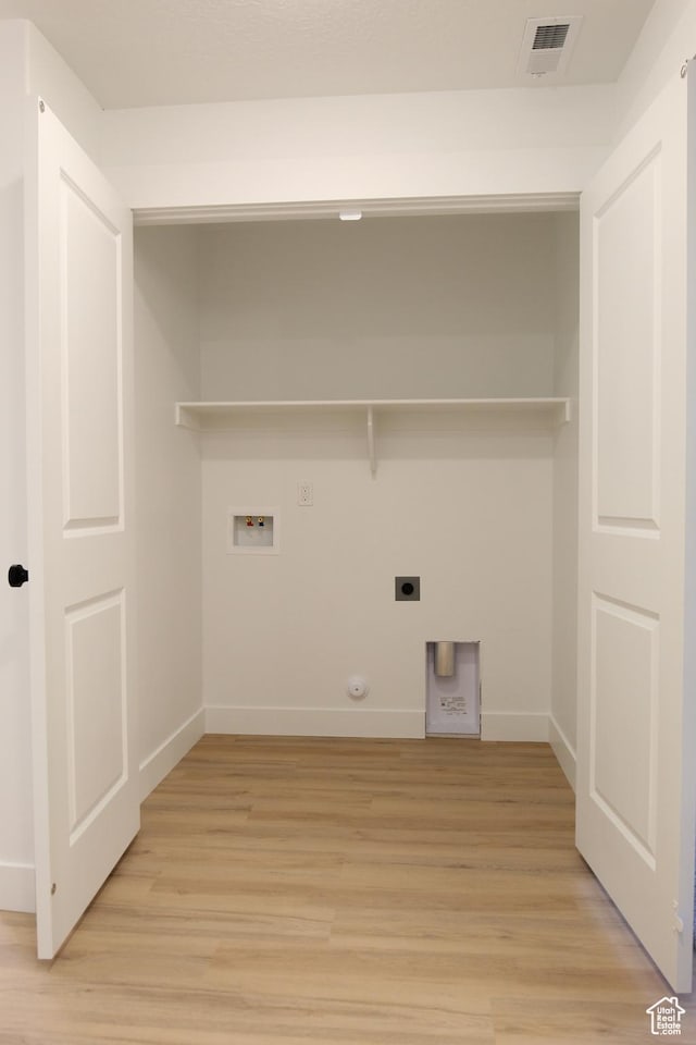 laundry area with hookup for a washing machine, hookup for a gas dryer, light wood-style floors, laundry area, and electric dryer hookup