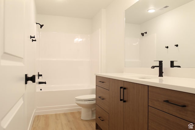 full bath with toilet, visible vents, vanity, shower / washtub combination, and wood finished floors