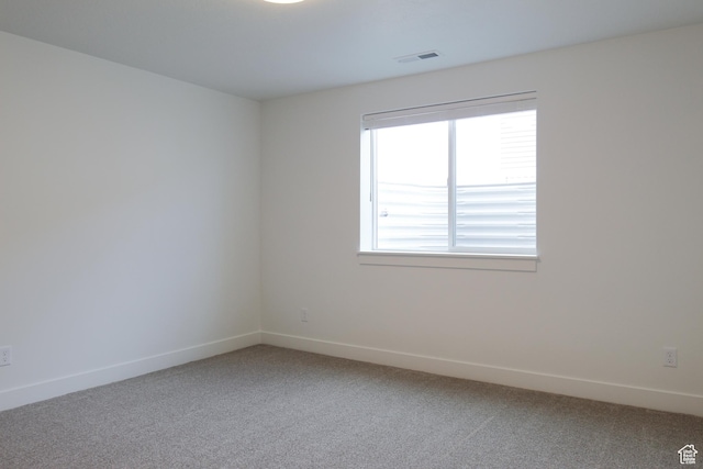 spare room with baseboards, carpet flooring, and visible vents