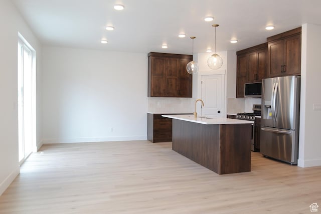 kitchen featuring baseboards, stainless steel appliances, and dark brown cabinetry