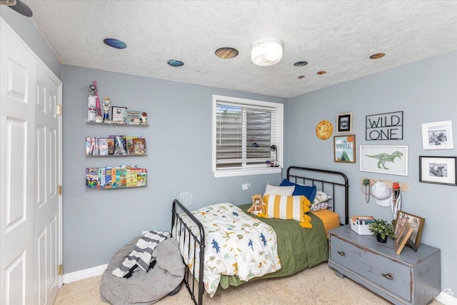 carpeted bedroom with baseboards and a textured ceiling