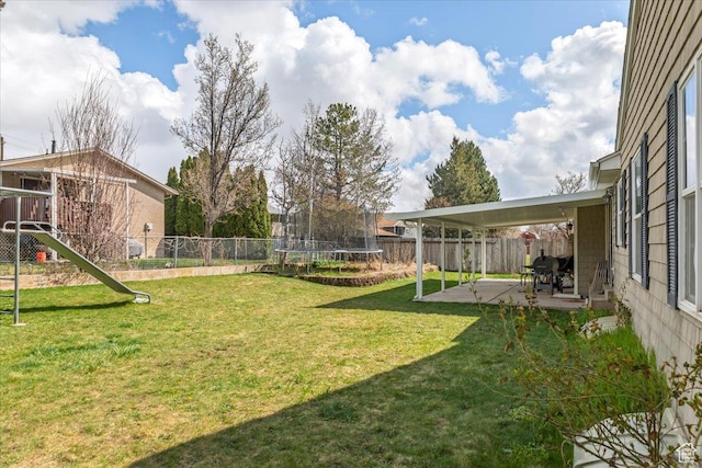 view of yard featuring a patio, a trampoline, and a fenced backyard