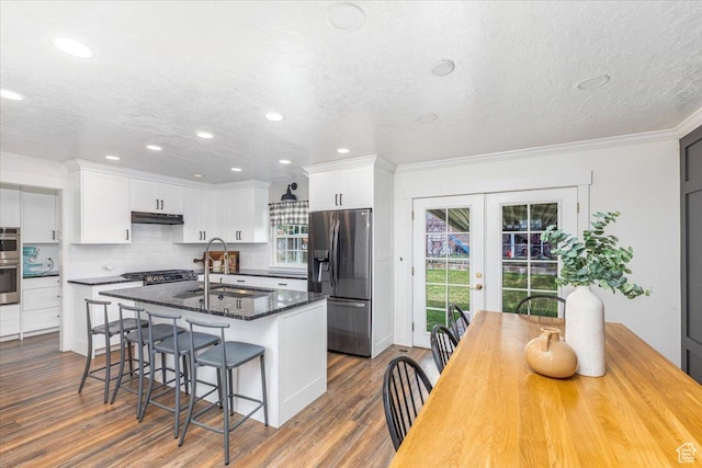 kitchen featuring french doors, a sink, tasteful backsplash, appliances with stainless steel finishes, and under cabinet range hood