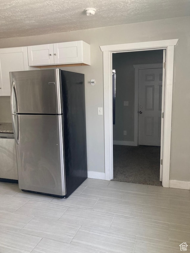 2855 Lincoln Ave, Ogden, UT 84401 - kitchen with baseboards, a textured ceiling, white cabinets, and appliances with stainless steel finishes
